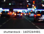 Defocused picture of night street car traffic - view from road. Colorful night life background.