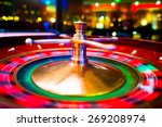 Gambling with colorful spinning fortune roulette wheel in casino with swallow depth of field on bokeh casino and city lights in the background