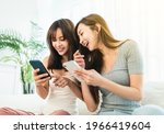 Happy young woman using their smart phones  sitting on a sofa  at home