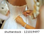 bridesmaid tying bow on wedding dress