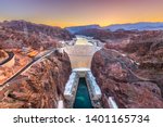 Hoover Dam on the Colorado River straddling Nevada and Arizona at dawn from above.