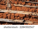 Small photo of Close up of a wattle and daub wall of a rural hut made of red clay and wood.
