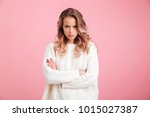 Picture of angry young woman standing isolated over pink background. Looking camera.