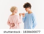 Small photo of Image of happy woman standing near her brother isolated over white background and made up by pinky while showing diddle gesture under back