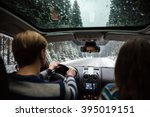 Back view of beautiful couple driving in car through winter forest