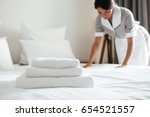 Young hotel maid making the bed with clean fresh towels