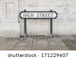 A High Street road sign in front of a white wall