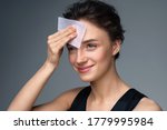 Small photo of Woman using facial oil blotting paper