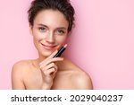 Woman with lipstick. Photo of woman with perfect makeup on pink background. Beauty concept