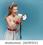 Small photo of Wroth pin-up girl yells through megaphone, mouthpiece, speaking trumpet. Filmmaking or film production concept / photo set of young American pin-up model on blue background