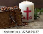 Small photo of Wooden cross with bible, rosary and paschal candle, easter religious concept