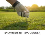 golfer tee off golf ball before swing, sunset time.