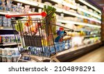 Small photo of A shopping cart with grocery products in a supermarket