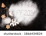 Merry Christmas and a happy new year 2021. Xmas concept with gingerbreads, christmas cookies, sifter, spilled sugar and the letters PF 2021 from above.