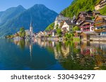 Scenic picture-postcard view of famous Hallstatt lakeside town reflecting in Hallstattersee lake in the Austrian Alps in beautiful morning light on a sunny day in summer, Salzkammergut region, Austria