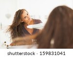 Young Woman Blow Drying Hair In ...