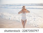 Small photo of happy elegant female in white beachwear at the beach relaxing.