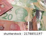The assorted Canadian dollar bills with a Queen Elizabeth on 20 dollar bill, surrounded by other blurry bills