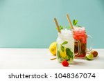 Fresh cocktail drinks with ice fruit and herb decoration. Alcoholic non-alcoholic drink-beverage. Mojito on blue background