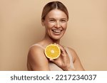Small photo of Beautiful Woman Smiling with Orange Fruit. Positive Woman with Radiant Face Skin and Orange Portrait. Girl Model with Natural Makeup and Glowing Hydrated Skin. Vitamin C Cosmetics Concept