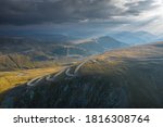 Aerial sunrise shot of a curved motorway road through the mountains at more than 2000m elevation - Transalpina, Parang Mountains 