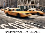 Abstract motion blur of a city street scene with a yellow taxi cabs speeding bY