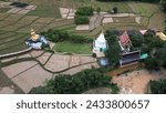 Small photo of PHRAE , THAILAND - DEC 4 ,2023 :Top view of a bamboo bridge to white pagoda and Phra Chao Ton Luang outdoor Buddha statue. Sitting in the a rice field at Wat Nakhuha there are beautiful natural places