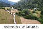 Small photo of PHRAE , THAILAND - DEC 4 ,2023 :Top view of a bamboo bridge to white pagoda and Phra Chao Ton Luang outdoor Buddha statue. Sitting in the a rice field at Wat Nakhuha there are beautiful natural places