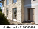 Modern house with stone cladding in summer sunshine with front door and windows, Austria, model house