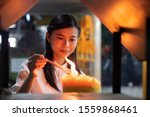 Small photo of Religious Asian buddhist woman pray and light up joss stick incense. Female buddhist disciple meditating, burning incense fragrance joss stick with flame for religious service in temple or monastery