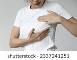 Small photo of Asian woman checking her chest at home, concept of breast cancer awareness month, breast cyst or tumor inspection, body care, precautionary preventive medicine, breast cancer awareness month concept