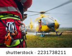 Small photo of Selective focus on safety harness of paramedic of emergency service in front of helicopter. Themes rescue, help and hope.