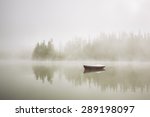 Boat On The Lake At Morning Fog.