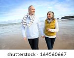 Cheerful senior people walking on the beach