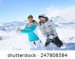 Couple in snowy mountain doing snowballs fight