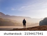 Small photo of A man is resting at ease by the calm lake. Relaxation vacation