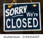 Sorry Were Closed sign in a window.