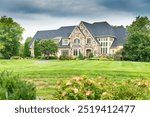  large country house under blue skies. Landscape with garden design, lawn and clouds.