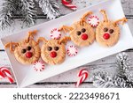 Christmas peanut butter red nose reindeer cookies. Overhead view table scene against a white wood background. Holiday baking concept.