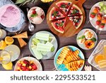Refreshing summer food table scene. Assorted grilled fruits, ice cream and ice pops. Above view on a dark wood background.