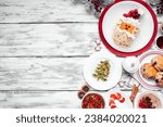 Christmas breakfast side border. Overhead view on a white wood background. Fun holiday food concept. Santa pancakes, scones, fruit and cereals. Copy space.
