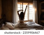 Young woman doing morning stretches in bed after wake-up