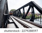 Passenger train pass through the River Kwai Bridge or Death railway bridge in Kanchanaburi, Thailand. It was part of the meter-gauge railway constructed by the Japanese during WW 2