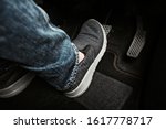 Close up the foot pressing brake pedal of a car. Driver stopping the car.