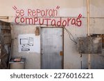 Small photo of Ensenada, Baja California, Mexico - February 15, 2023: "Computers are repaired" sign painted on a house wall in a poorer district.