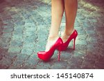 woman legs in red high heel shoes outdoor shot on  cobble street