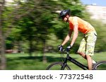 Small photo of a young man goes for a drive on a sporting bicycle on a background nature, sky, stone and afoot