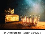 Small photo of low key image of beautiful queen or king crown and gold treasure chest. vintage filtered. fantasy medieval period