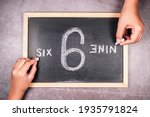 Hand writing from the point of view of 6 and 9 number on chalkboard in opposite direction, argument in different perspectives concept