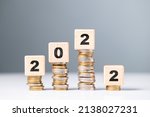 Small photo of 2022 with heap of coins stairs is drop at the last step, business, economic recession at the last quarter of the year